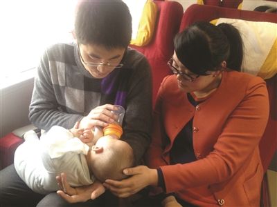 在列车上朱虹和丈夫正照顾小宝宝。 在列车上朱虹和丈夫正照顾小宝宝。