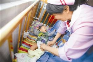 高雷 医护人员给小七换尿布。 晶报记者 高雷/文、图 高雷 医护人员给小七换尿布。 晶报记者 高雷/文、图