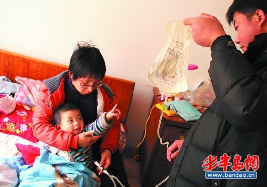 小敬东看着爸爸孙丰利举着的透析液。 小敬东看着爸爸孙丰利举着的透析液。