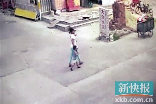 女嫌疑人将小杰带走。视频截图翻拍 女嫌疑人将小杰带走。视频截图翻拍